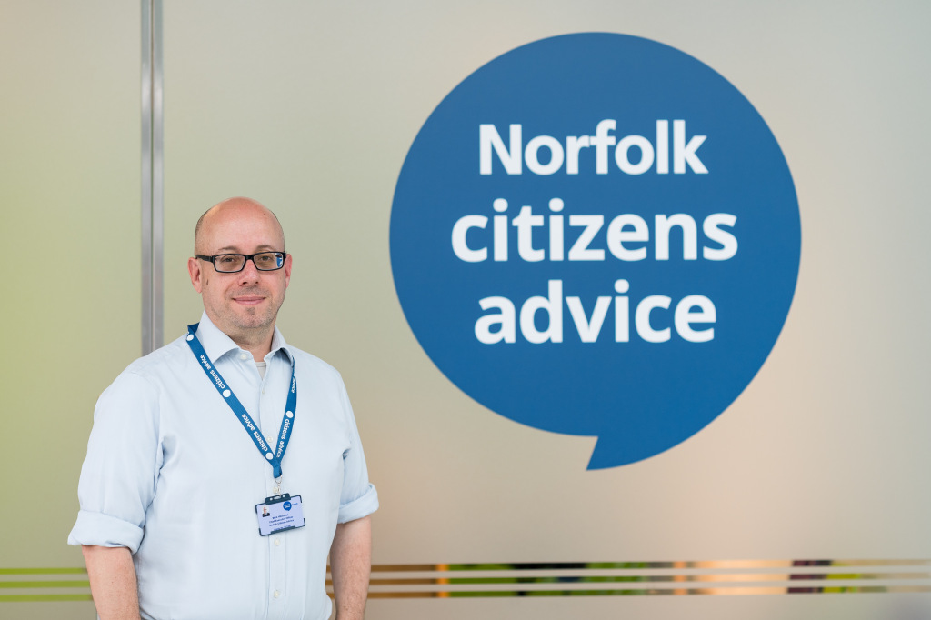 A man standing next to a Citizens Advice sign